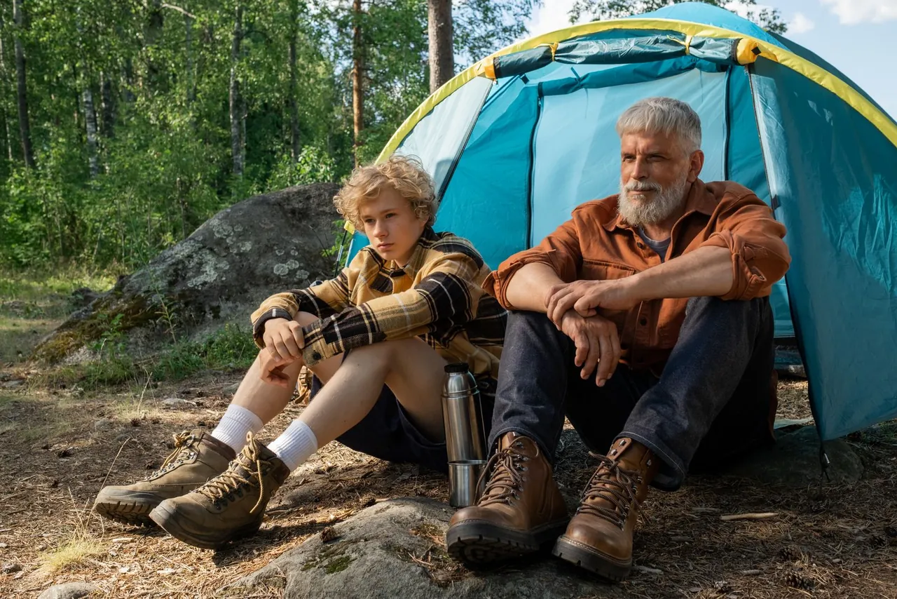 A couple relaxing in camping chairs beside their tent